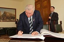Lech Wałęsa wpisał się do pamiątkowej księgi.