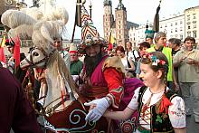 Lajkonik w towarzystwie młodej krakowianki ubranej w tradycyjny strój krakowski.