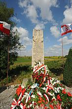 Kamienny słup przypomina, że w tym miejscu 6 sierpnia 1914 roku zaczęła się wojna nieistniejącego jeszcze Państwa Polskiego z Ro