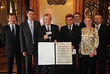 Grupa "azetesiaków" demonstruje Srebrny Medal Cracoviae Merenti i dokument podpisany przez Przewodniczącą Rady Miasta 