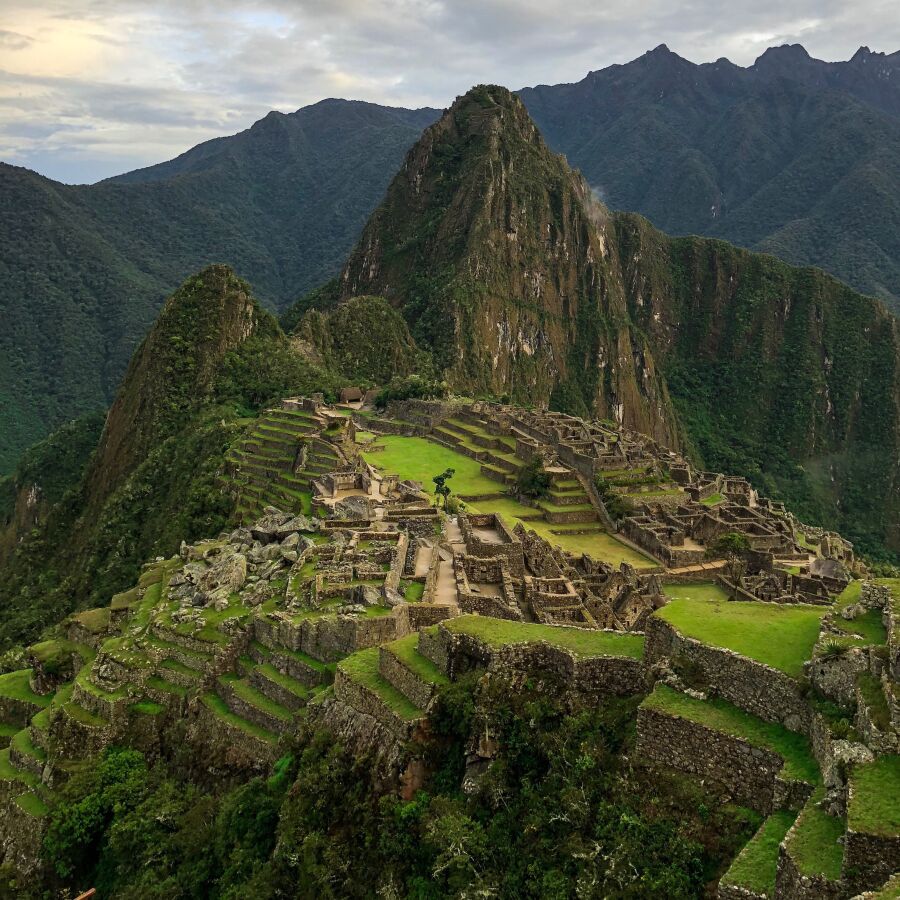 Machu Picchu - widok na ruiny historycznych obiektów na zielonych wzgórzach Peru.